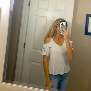 a white, tank top with an off the shoulder sleeve